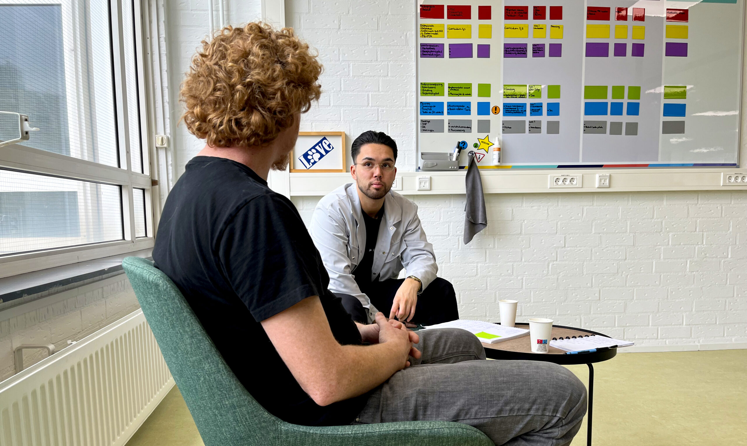 Twee mannen voeren een verdiepend gesprek, symbool voor de kracht van leiderschap gebaseerd op dialoog en nabijheid